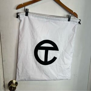 This is a white Telfar dust bag with a black logo, used for storing Telfar